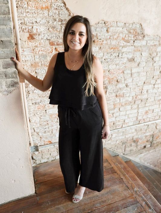 Stylish Black Linen Pants Set: Sleeveless Tiered Top and Drawstring Pants. Versatile outfit perfect for dressing up with heels or down with sneakers/sandals. Ideal for beach days, spring outings, or layering with a denim jacket. Lightweight, true-to-size fit with a classic style.